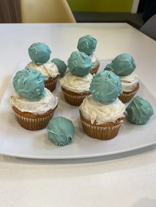 Cupcakes con esferas turquesa sobre una bandeja blanca